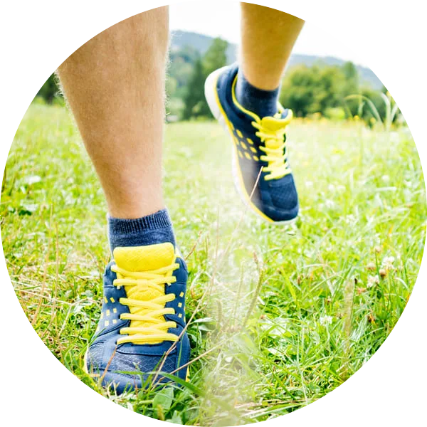 man walking through grass in colorful sneakers