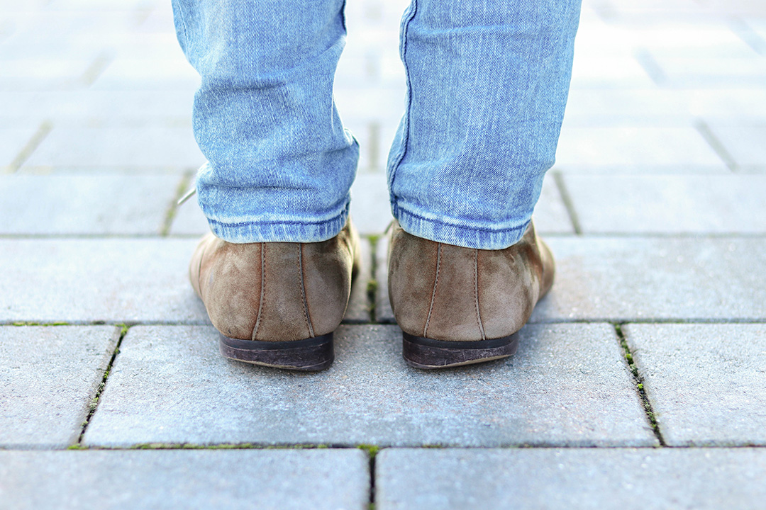 Schuhpaar von Hinten mit abgelaufenen Hacken zu sehen.