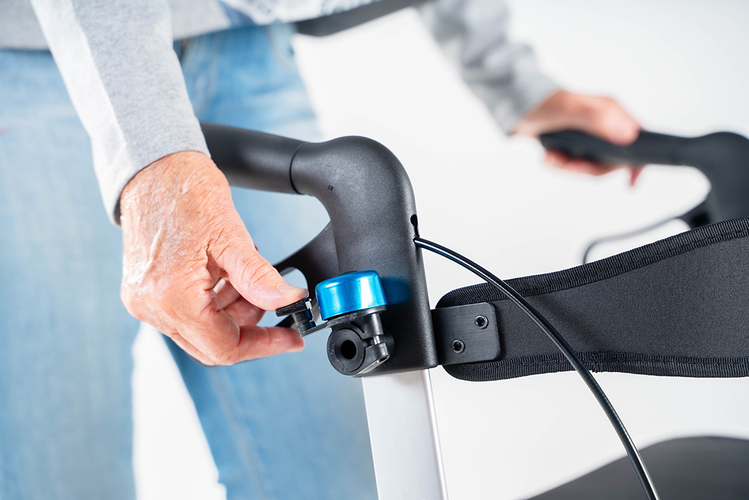 An einem Rollator wird eine Rollatorklingel bedient