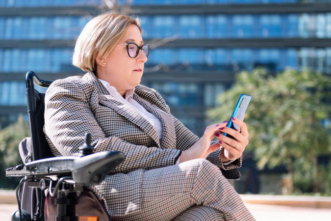 businesswoman-using-wheelchair-typing-on-mobile-2023-11-27-05-07-52-utc.jpg