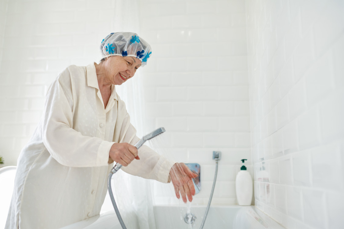 elderly-woman-in-bathrobe-filling-bathtub-with-wat-2023-11-27-05-07-44-utc.jpg