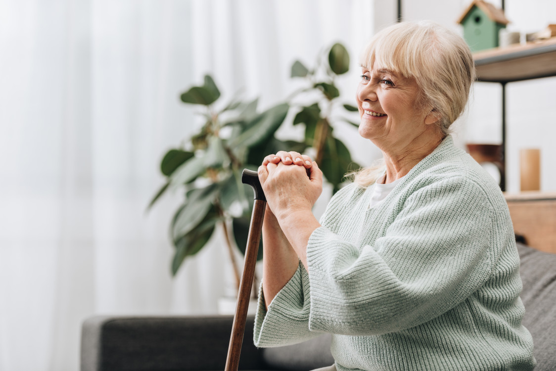 cheerful-retired-woman-smiling-and-holding-walking-2023-11-27-04-50-25-utc.jpg