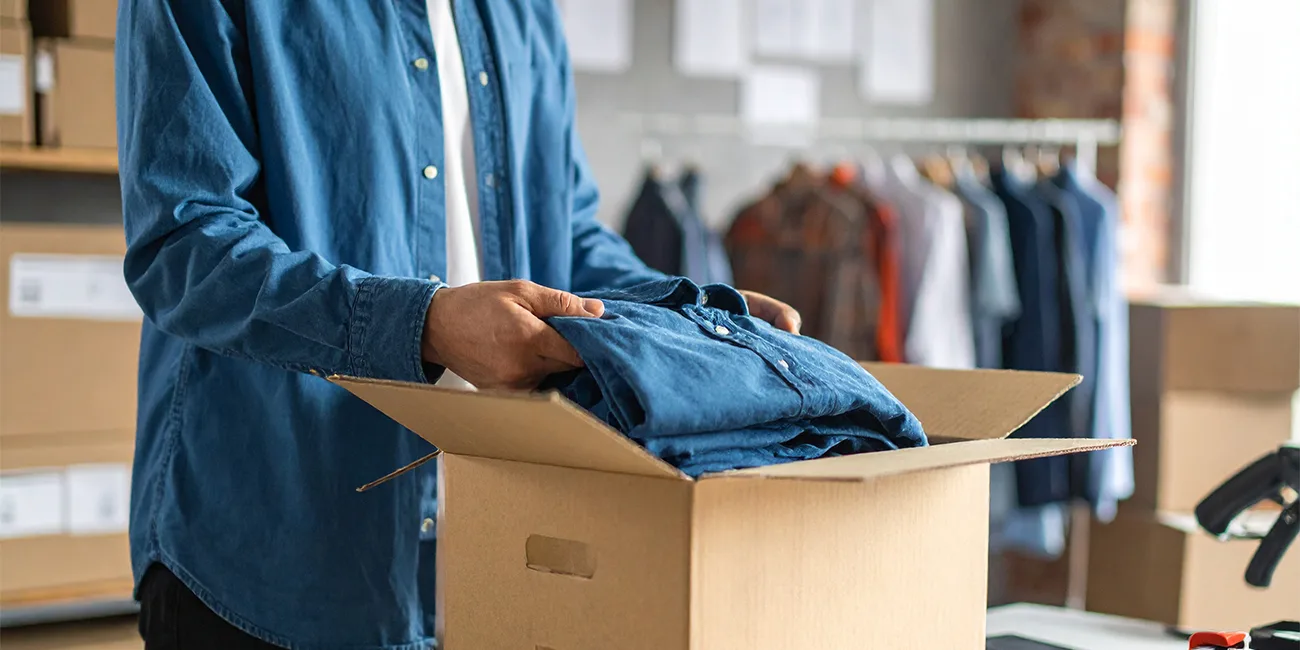 mand pakker en skjorte til forsendelse 1300x650