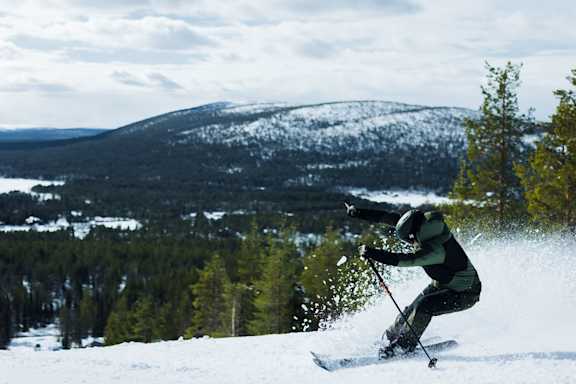Laskija pöllyttää lunta tunturissa