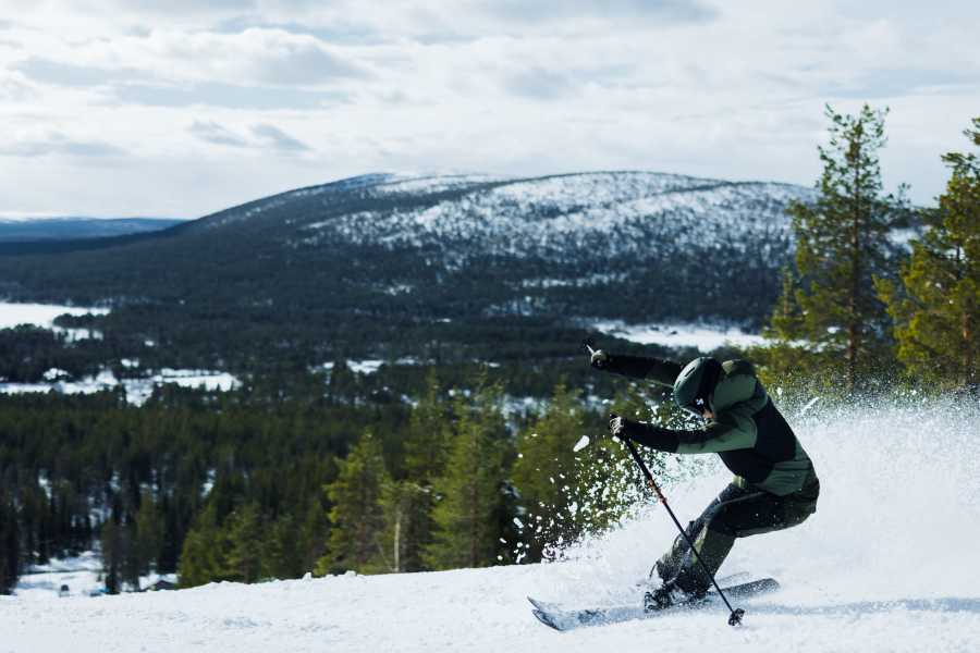 Laskija pöllyttää lunta tunturissa