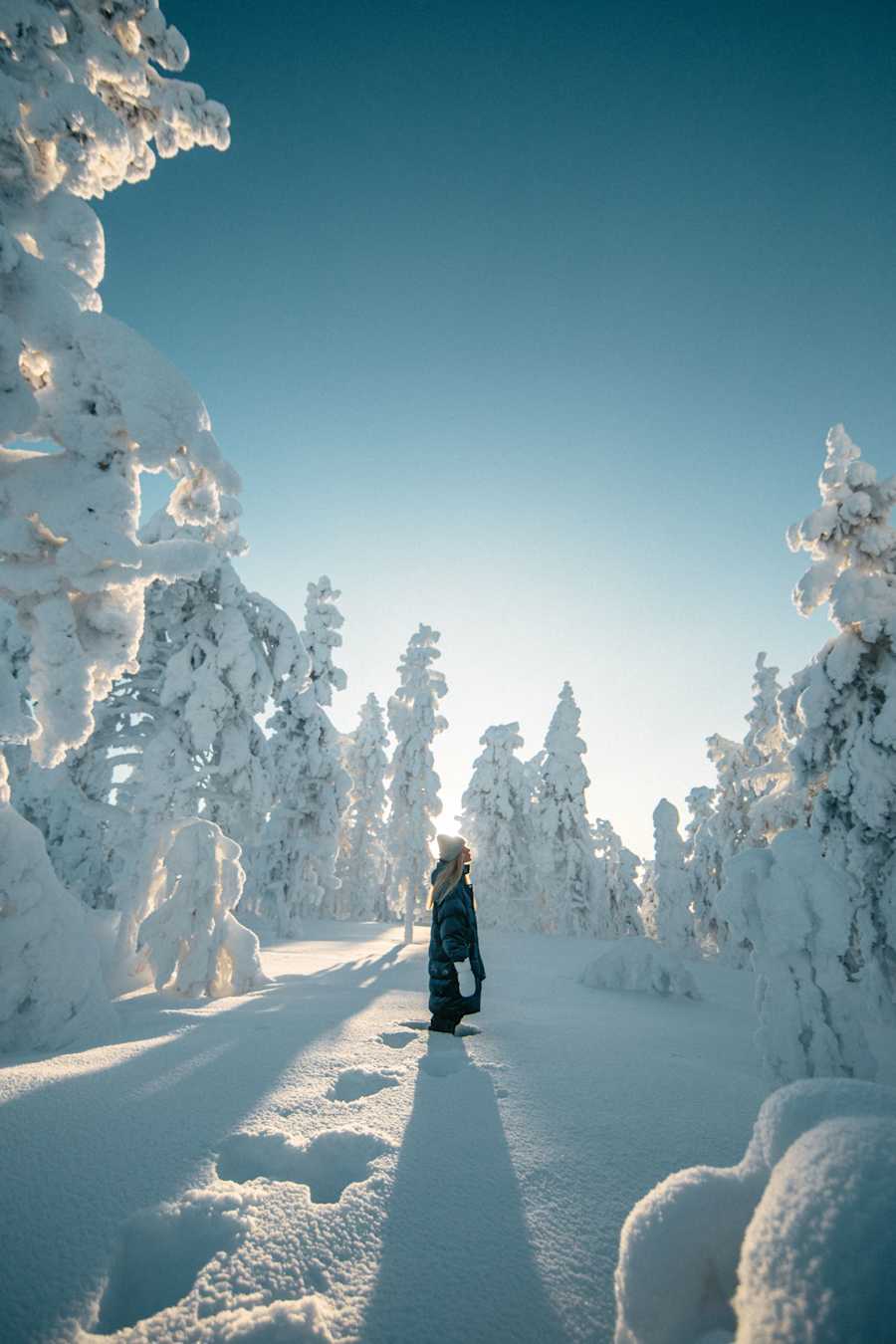 Nainen tykkylumipuiden keskellä