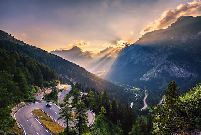 Aerial view of Maloja Pass road in Switzerland at sunset. 