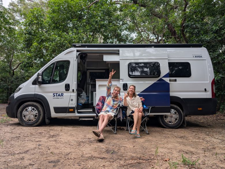 Een stel zit voor een camper in Australië