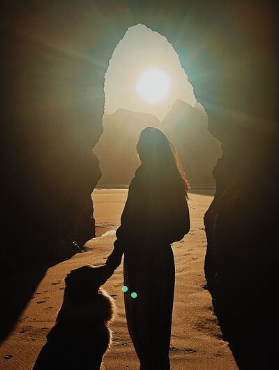 woman and dog in a cave in portugal by the sea