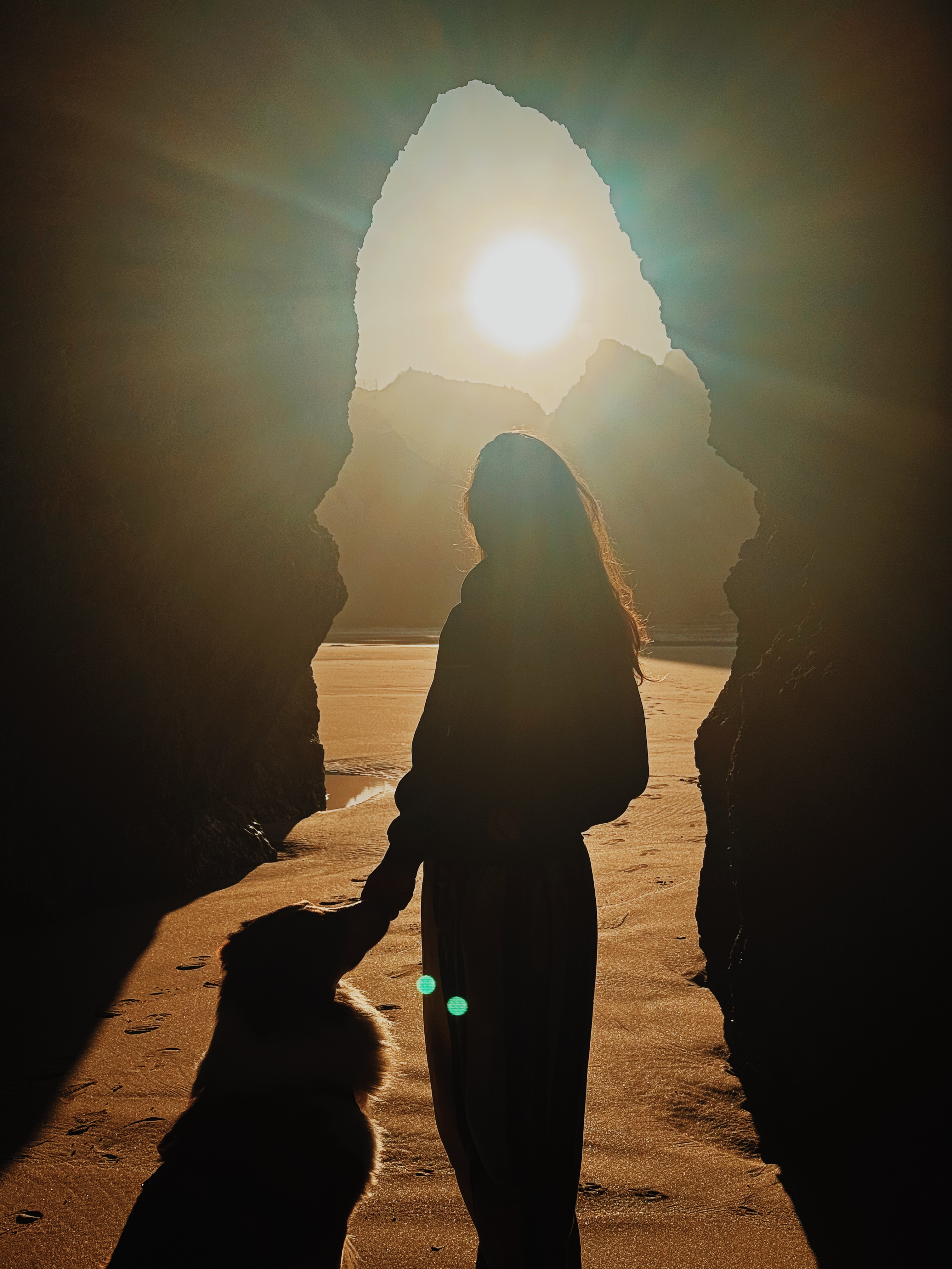 Frau mit Hund in einer Höhle an der Algarve