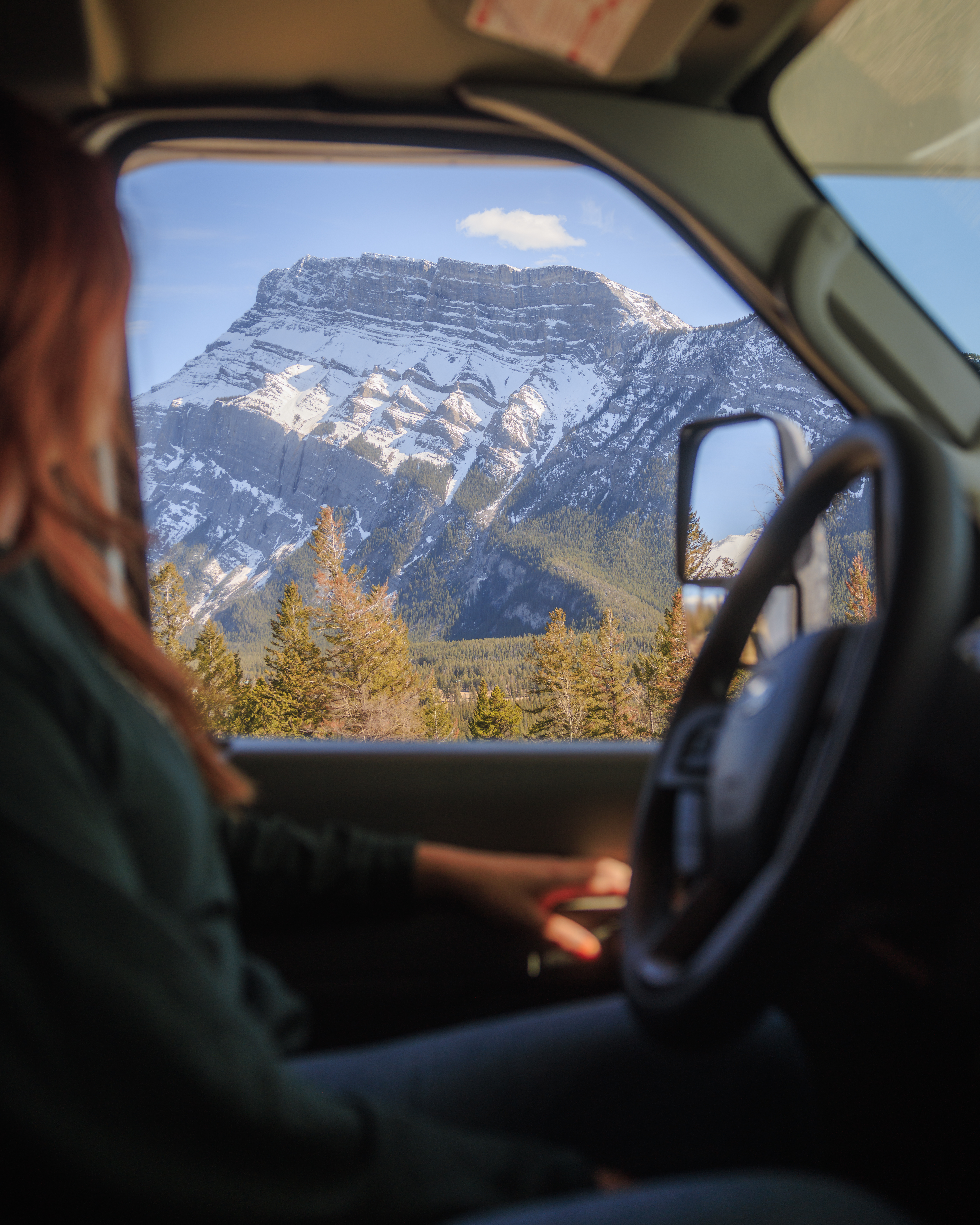 Frau schaut aus dem Wohnmobil in Kanada auf die Berge