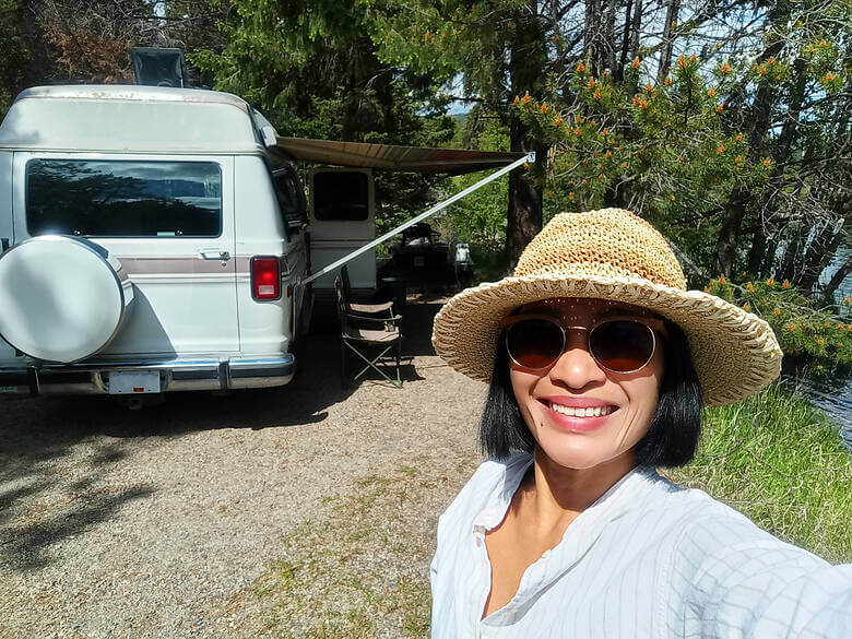 Frau macht ein Selfie vor ihrem Camper in Kanada