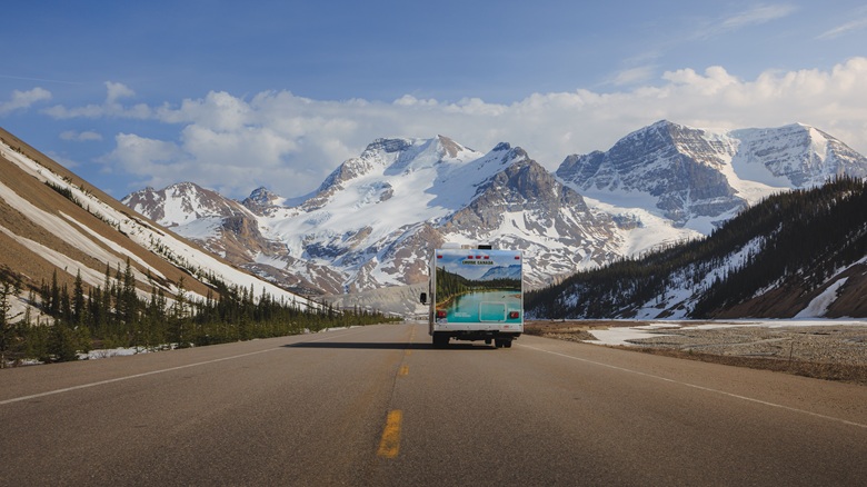 Wohnmobil fährt auf schneebedeckte Berge in Kanada zu