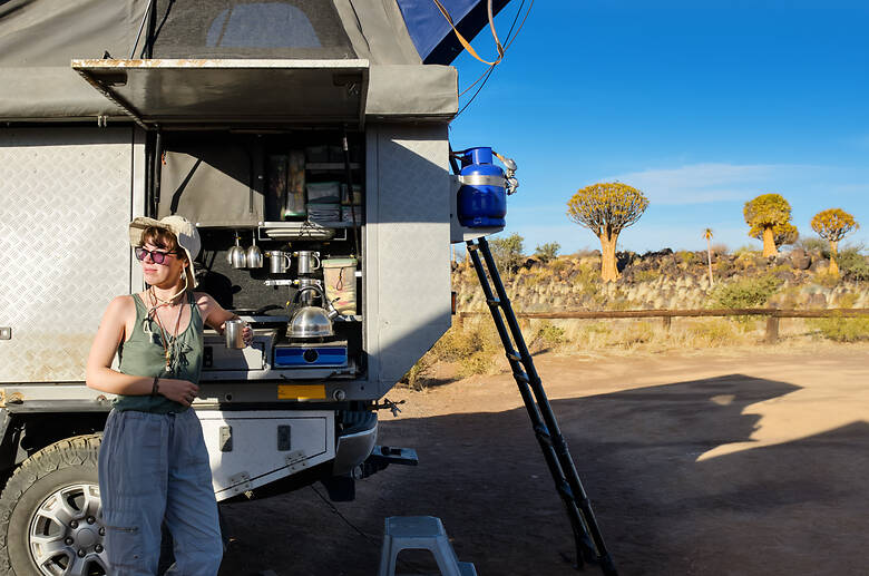 Frau kocht einen Kaffee auf dem Camping-Kocher im Outback