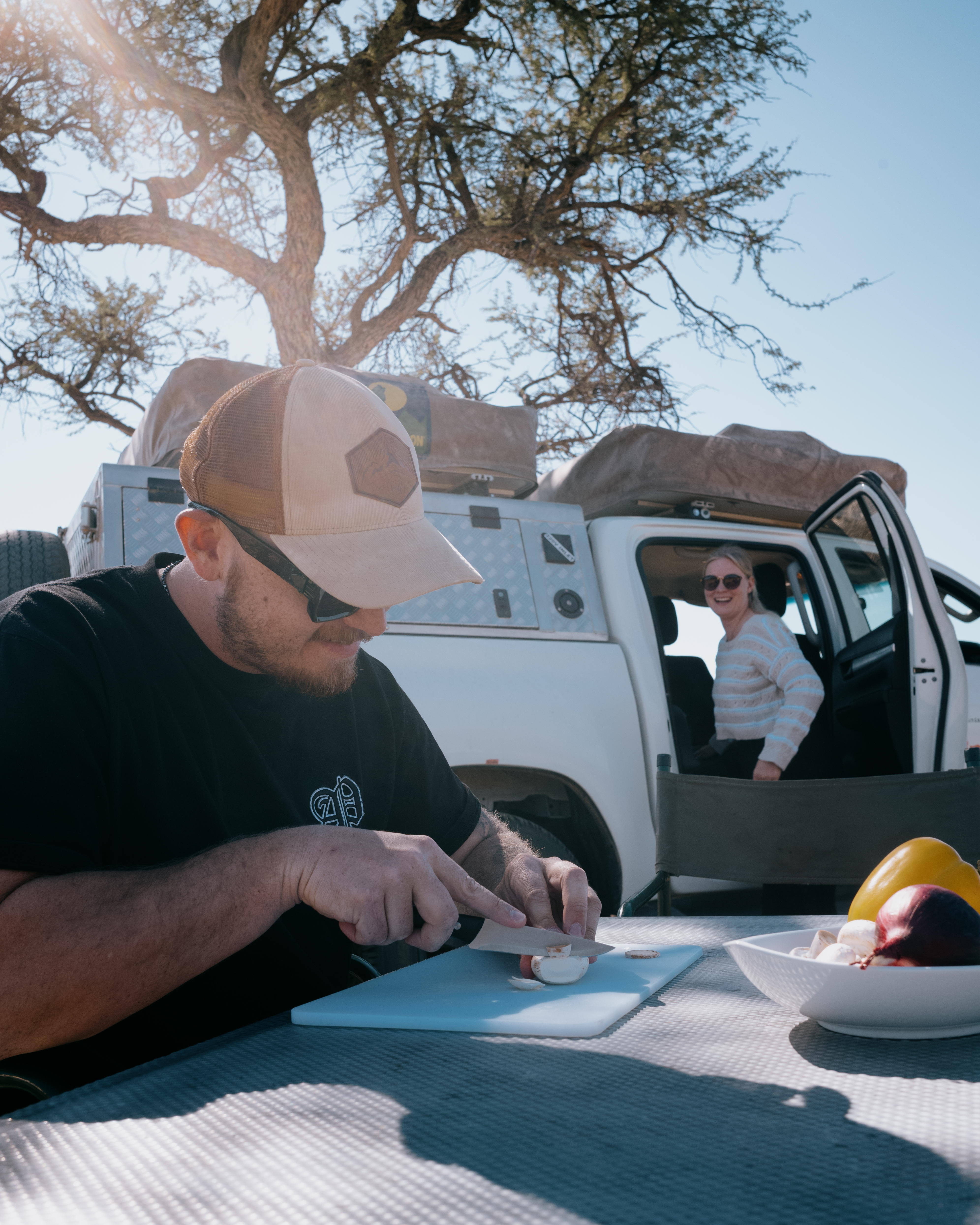 Mann bereitet Essen auf einem Campingplatz zu