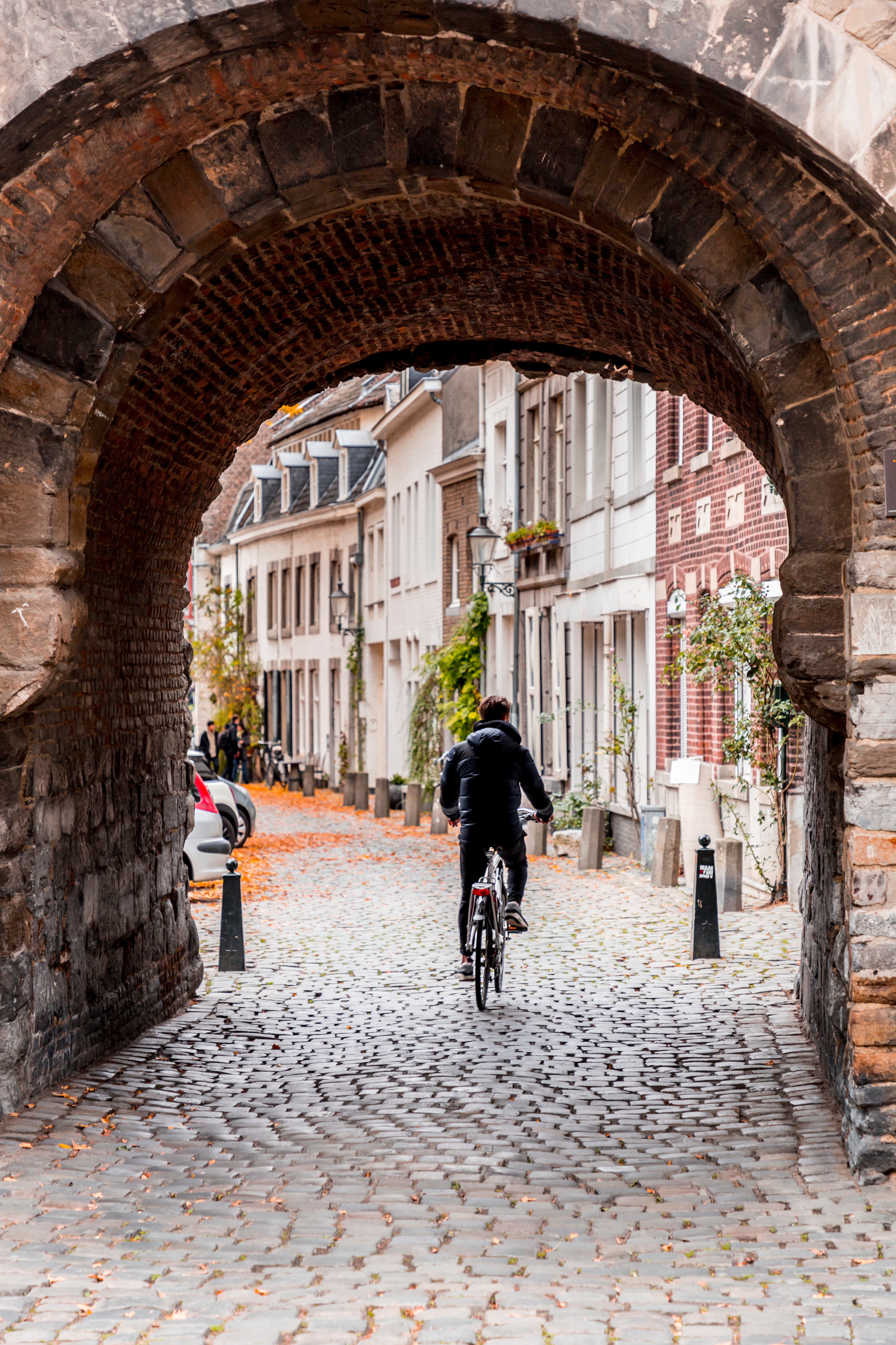 Man in de oude binnenstad van Maastricht met een fiets