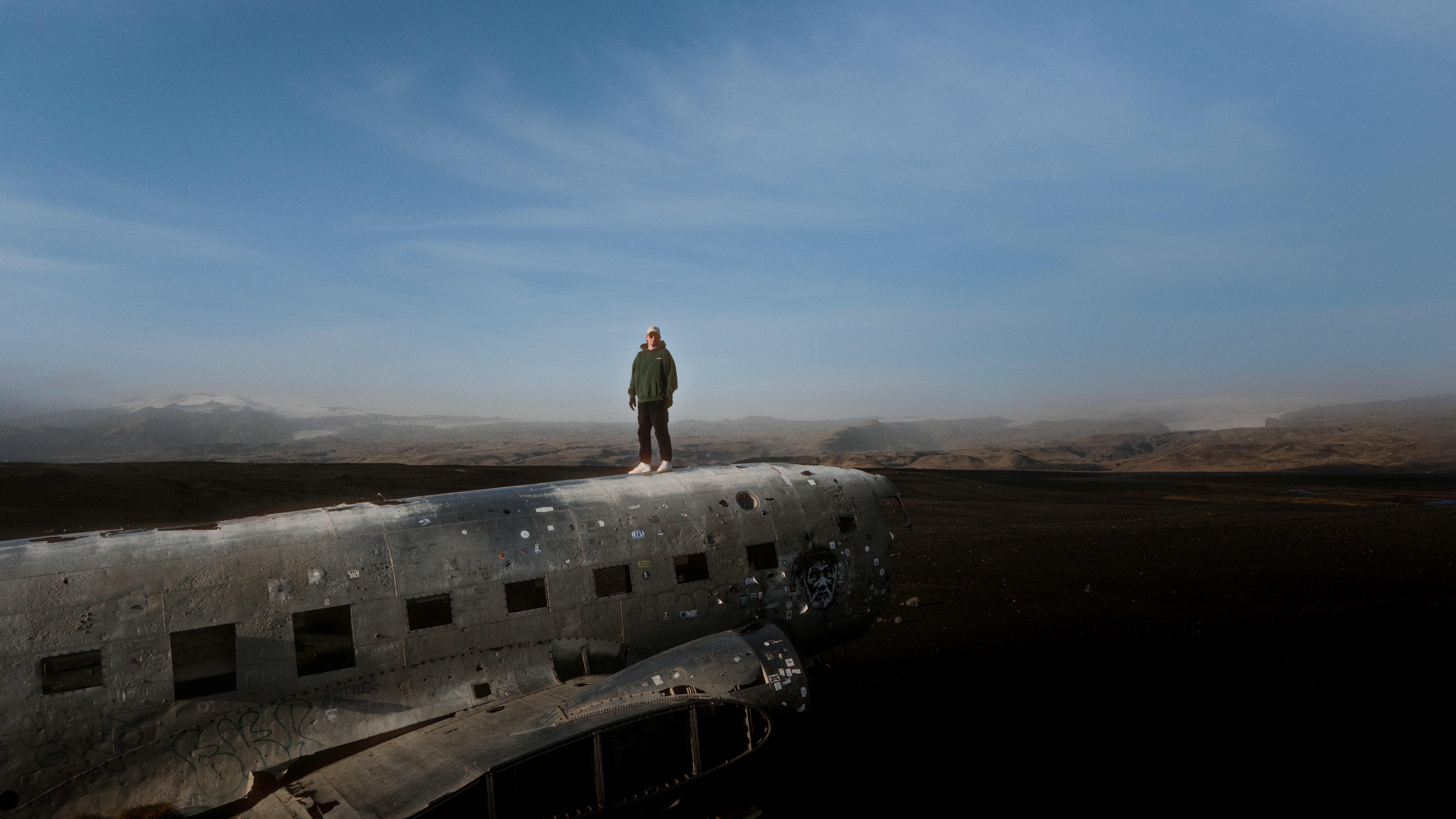 Mann steht auf einem Flugzeugwrack in Island 