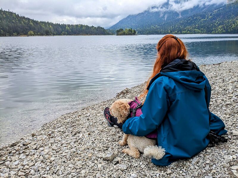 Frau mit Hund an einem Bergsee in Bayern