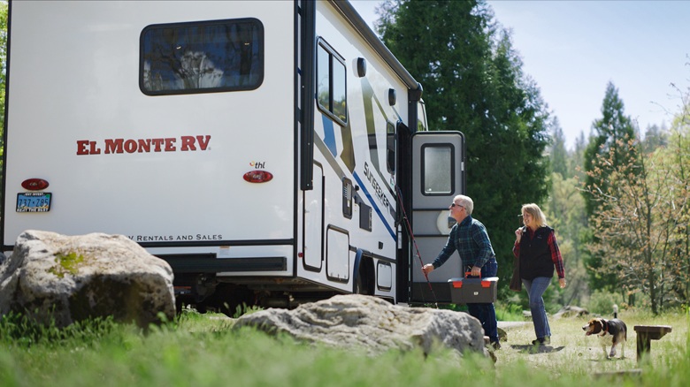 Älteres Paar mit einem Hund vor Wohnmobil El Monte C-25