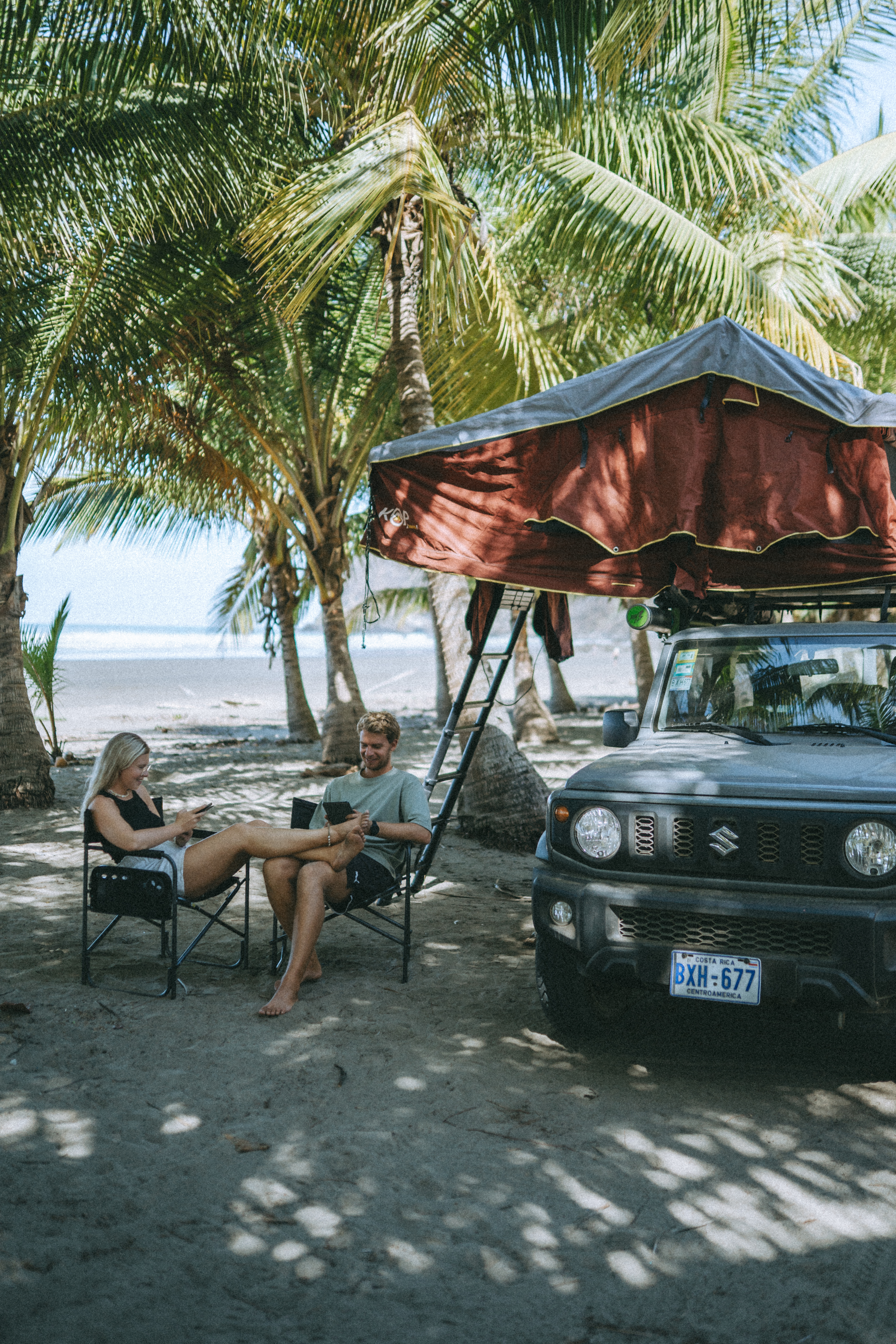 Paar mit Camper unter Palmen in Costa Rica