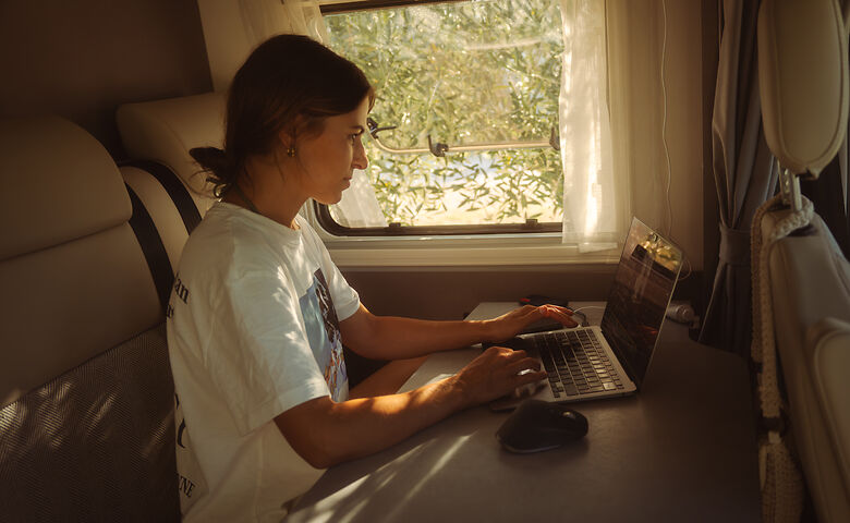 Frau arbeitet im Camper 