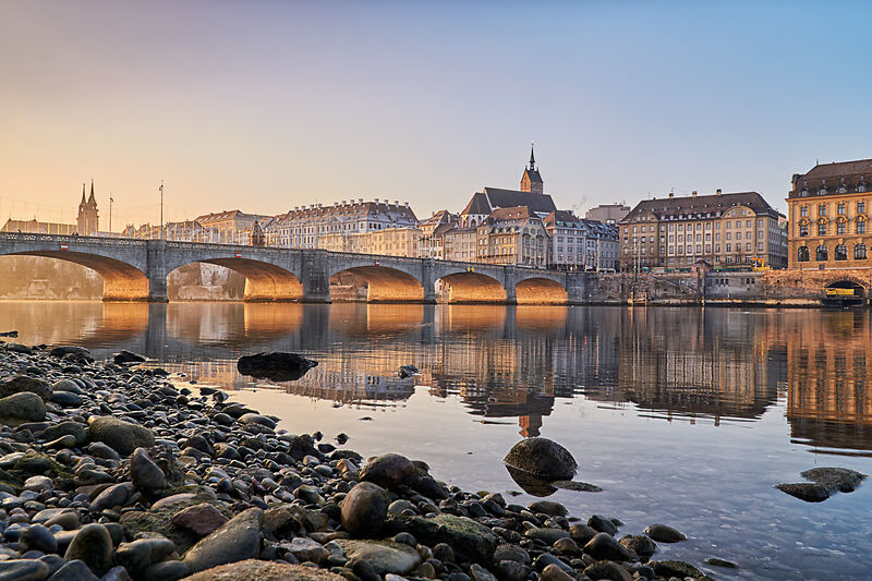 Blick auf die Mittlere Brücke und die Altstadt von Basel am Rhein bei Sonnenaufgang.