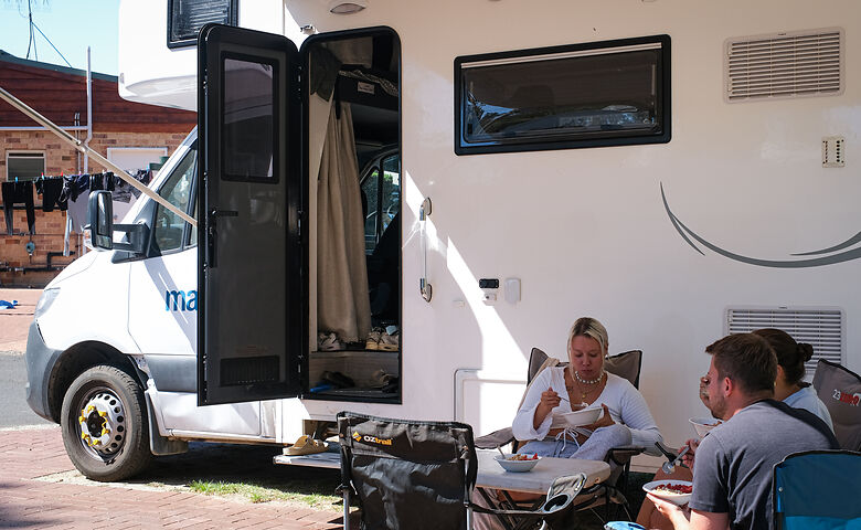 Freundeskreis isst gemeinsam am Camper