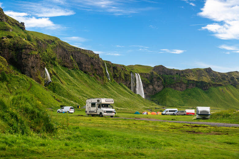 Wohnmobile campen vor einem Wasserfall in Island 