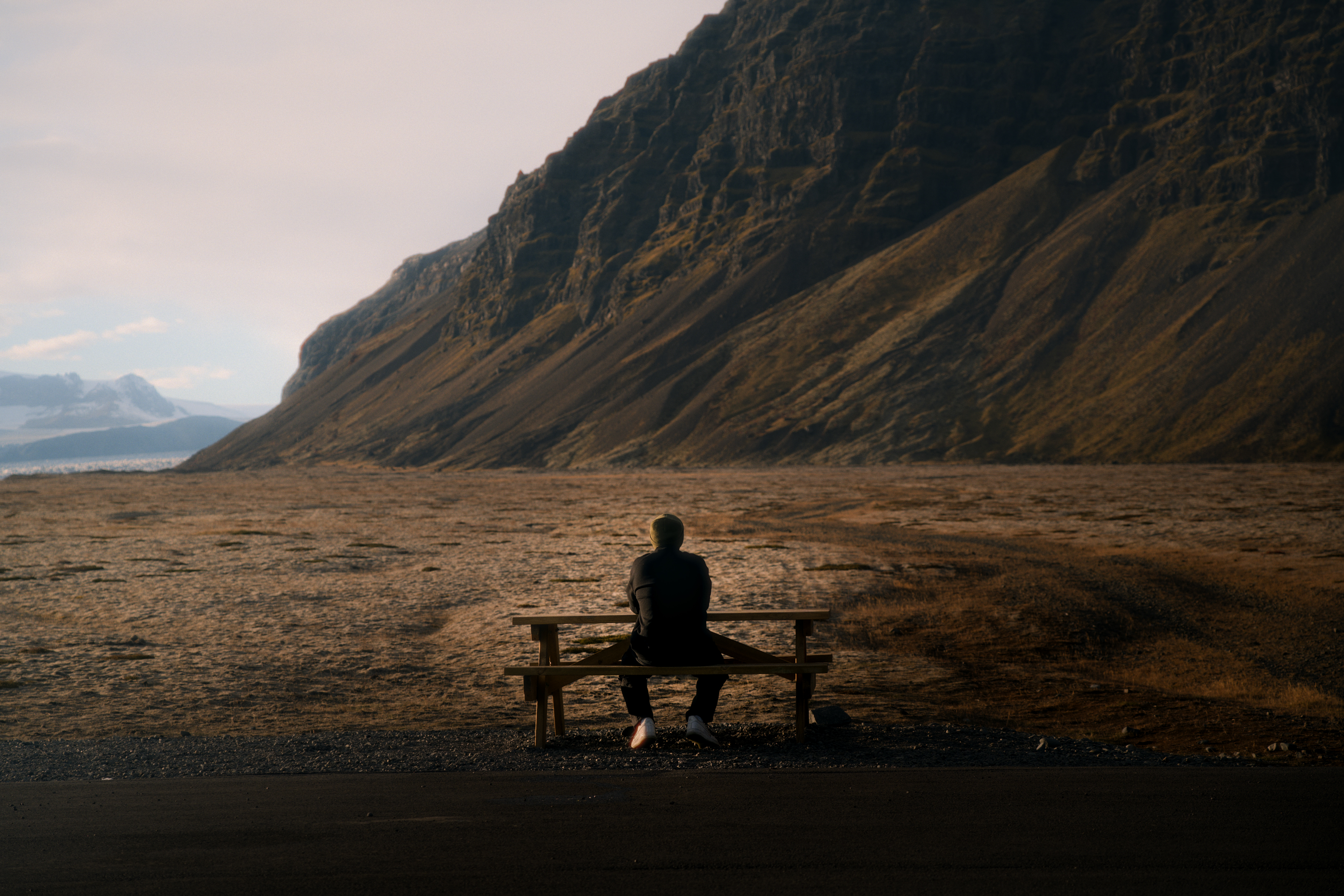 Mann mit Jacke sitzt auf einer Bank in Island 