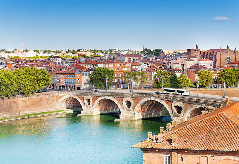 Blick auf die Brücke Pont Neuf und die Altstadt von Toulouse am Fluss Garonne an einem sonnigen Tag.