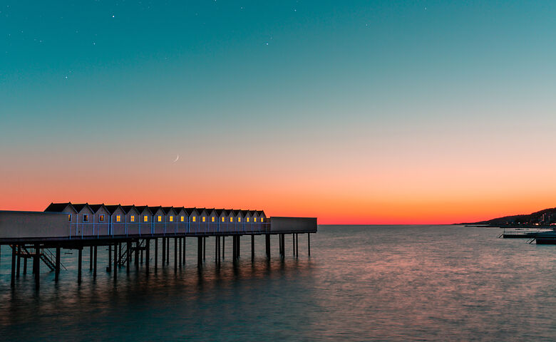 Sonnenuntergang an einem Holzsteg am Meer in Südschweden