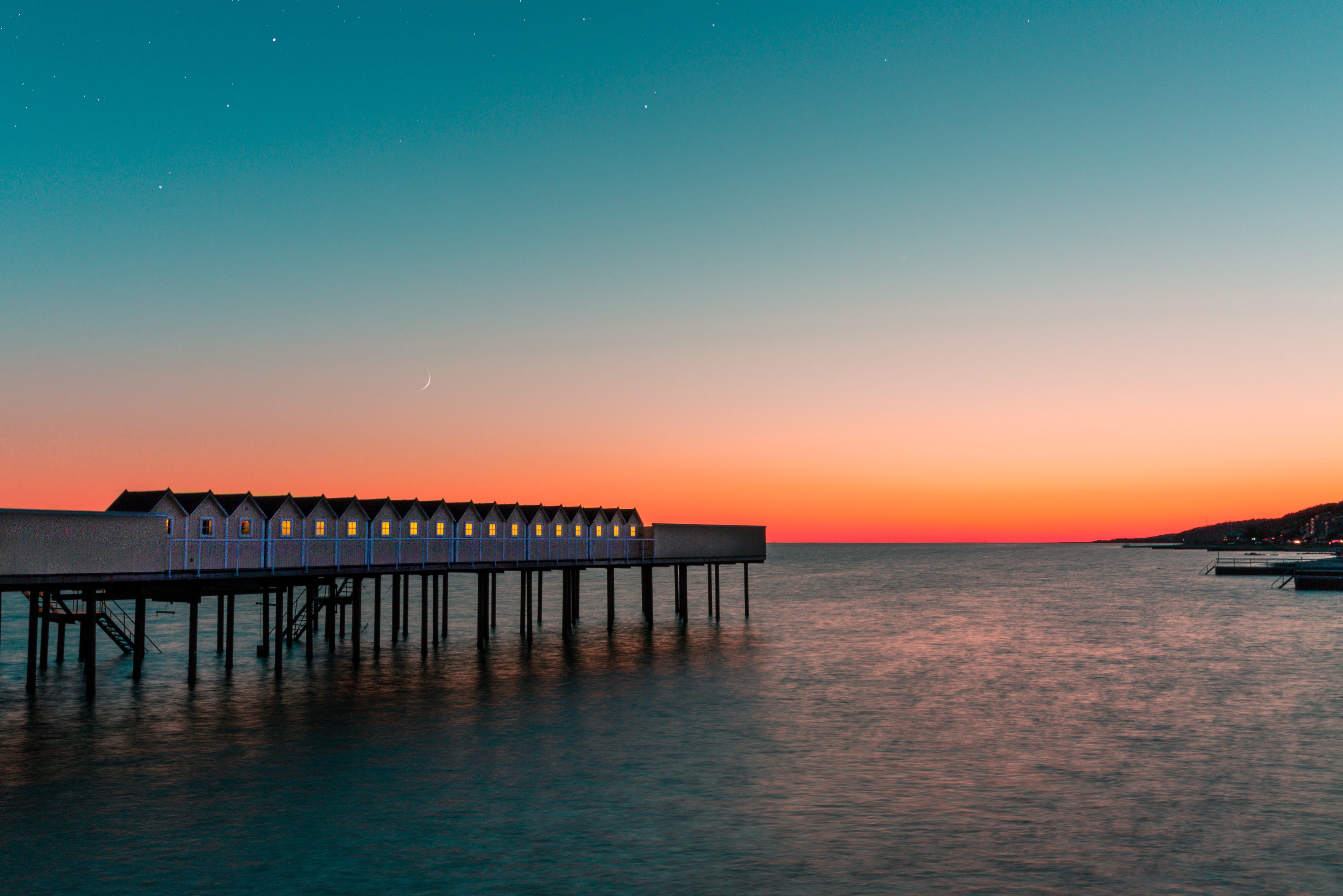Sonnenuntergang an einem Holzsteg am Meer in Südschweden