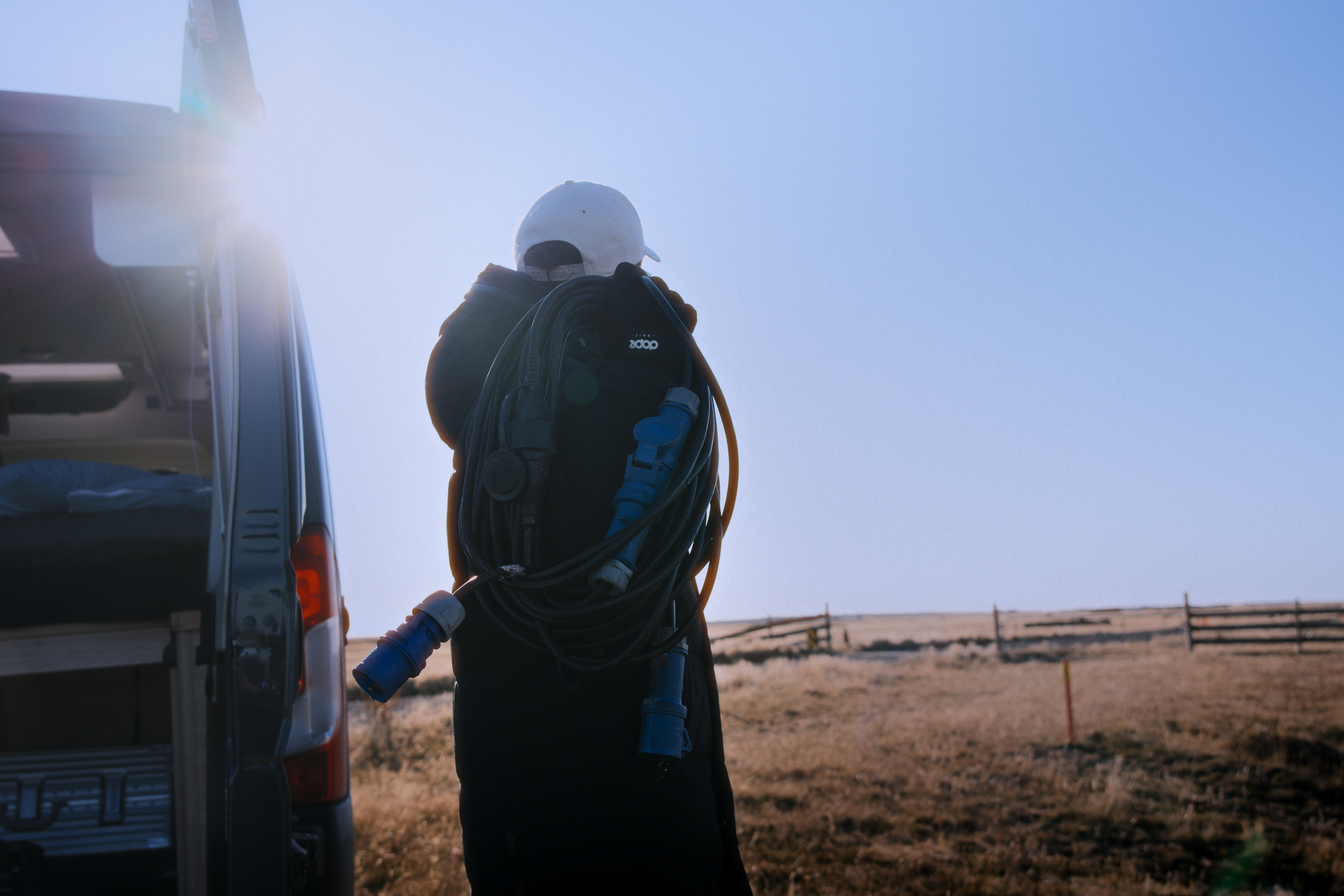 Mann trägt Stromkabel zum Camper 