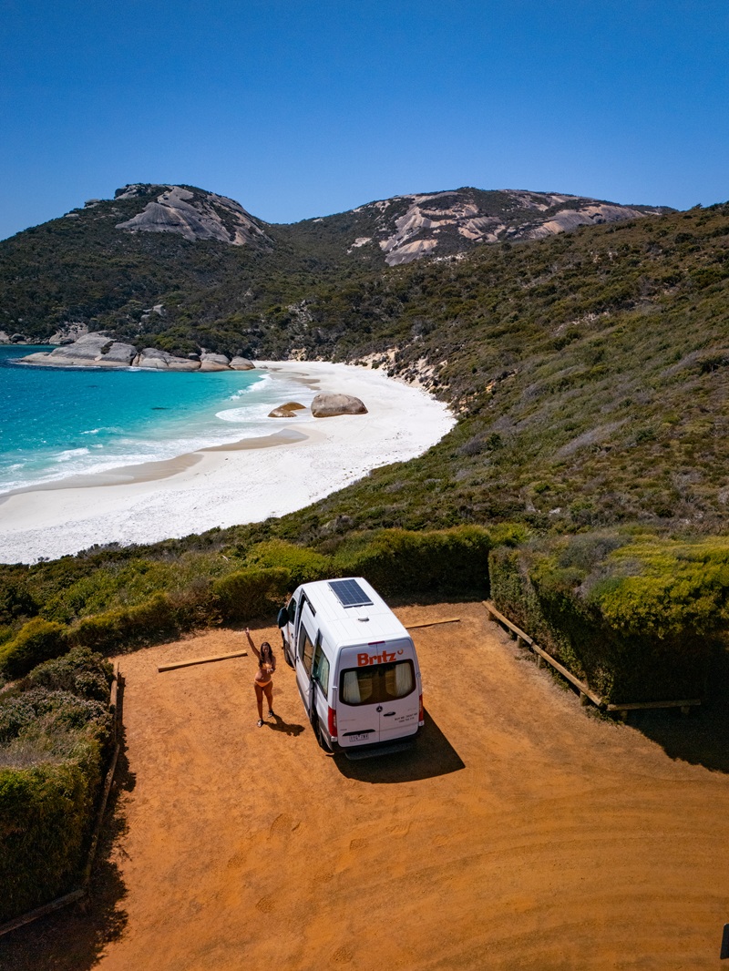 Frau mit Camper am Meer in Australien
