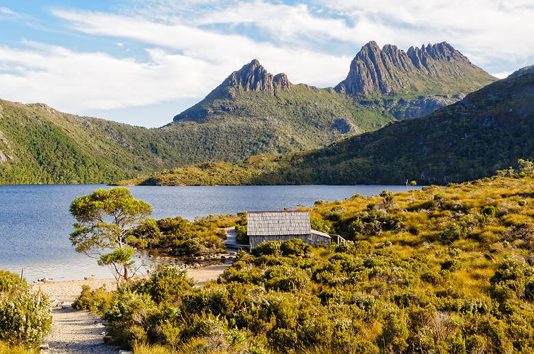 Hütte in Tasmanien an einem See mit Bergen im Hintergrund