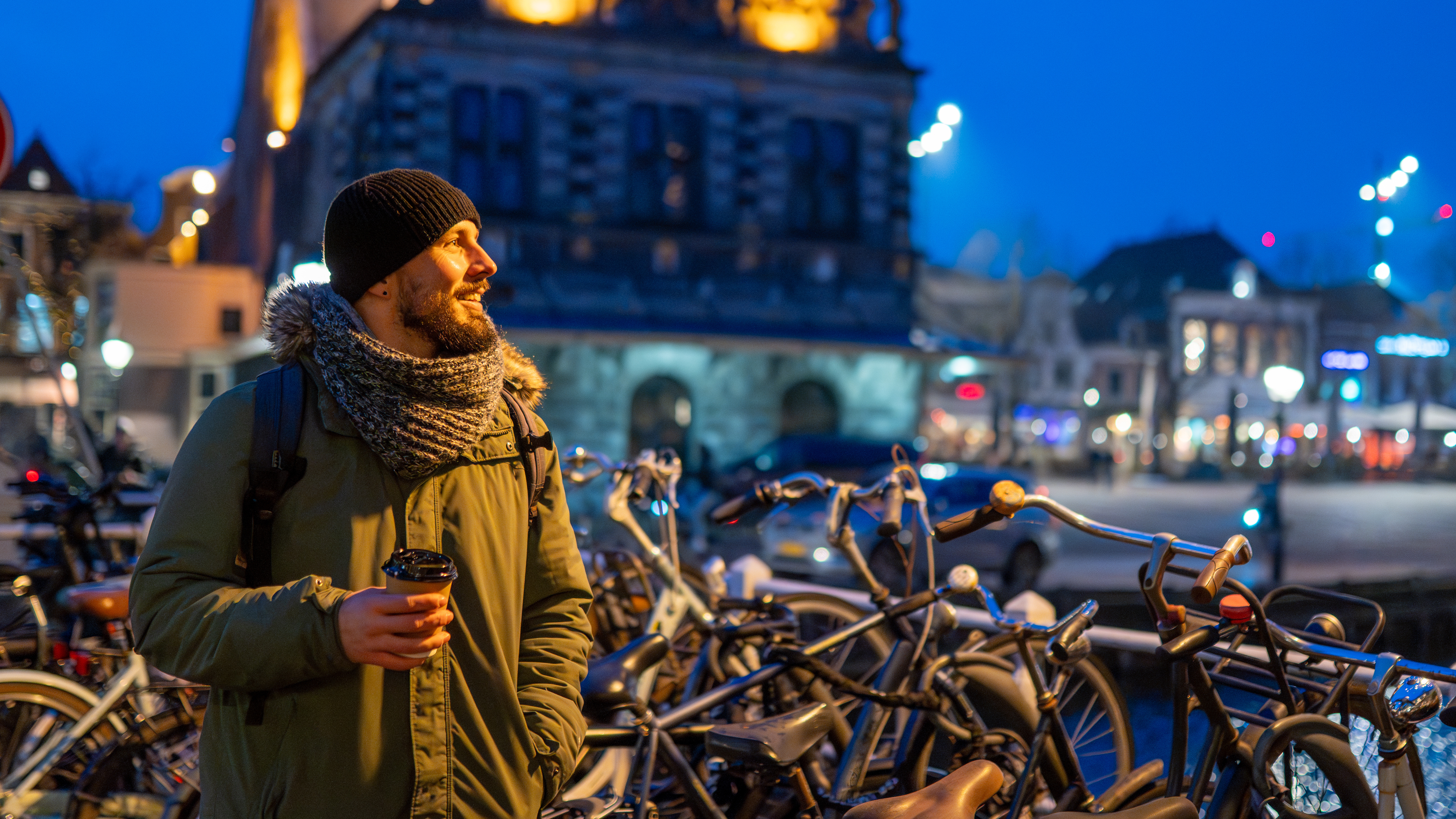 Man voor fietsen in de stad Groningen 's avonds
