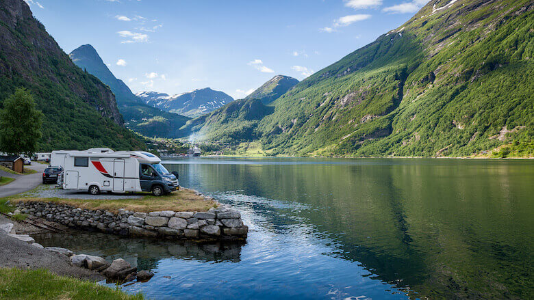 Eco-camping: camper rijdt langs een weg in een idyllische omgeving.