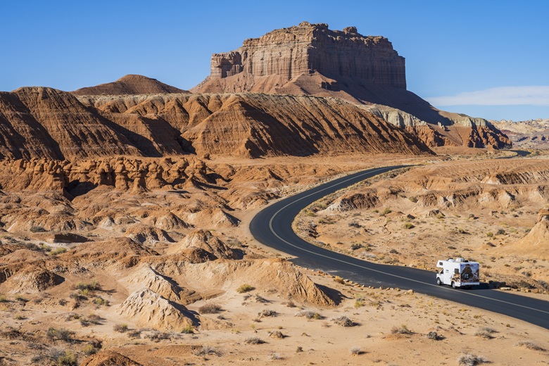 Wohnmobil fährt durch Landschaft mit Canyons in den USA