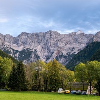 Wohnmobil in der Natur mit Campern, die vor ihrem Wohnmobil sitzen