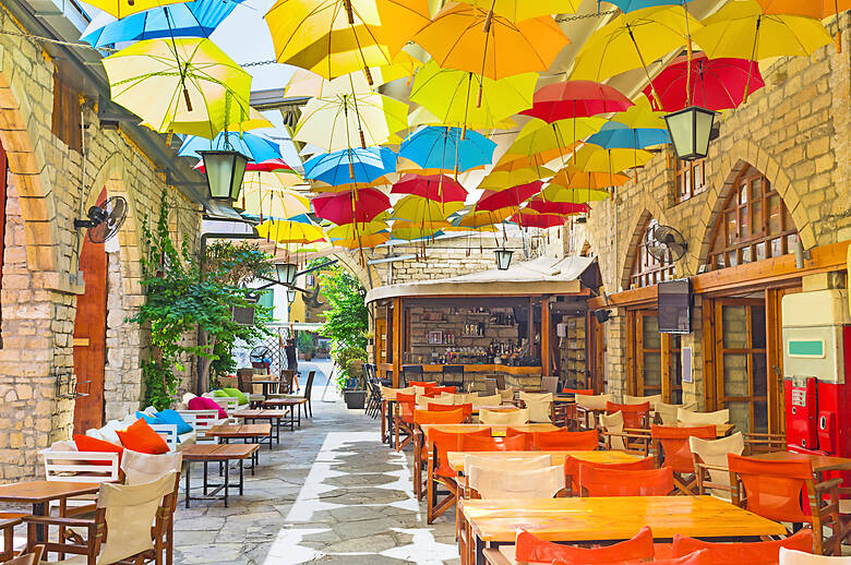 Bunte Sonnenschirme über einer Straße mit Restaurants in Limassol, Zypern