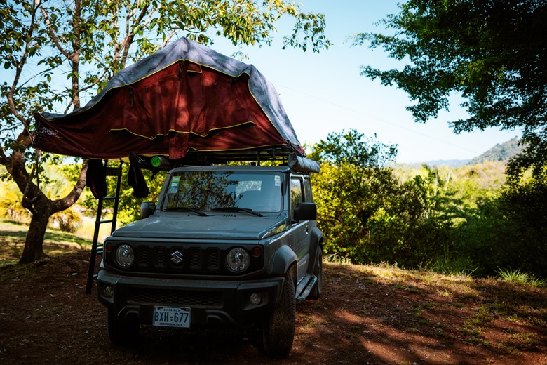 Camper mit Dachzelt zwischen Bäumen in Costa Rica