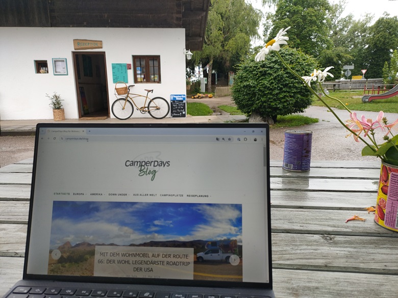 Eingeschalteter Laptop auf einem Campingplatz