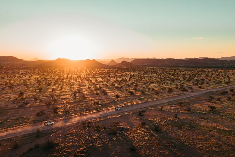 Allrad-Camper fahren bei Sonnenuntergang durch die namibische Landschaft