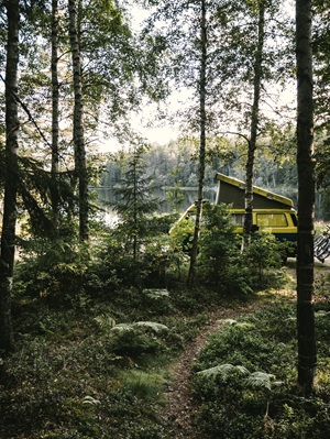 Grüner Camper an einem See in der Natur