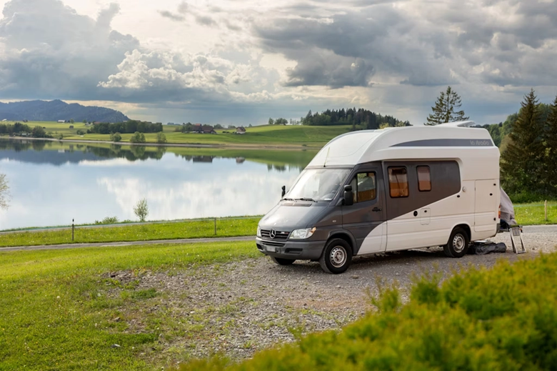 Wohnmobil parkt direkt an einem See in der Natur