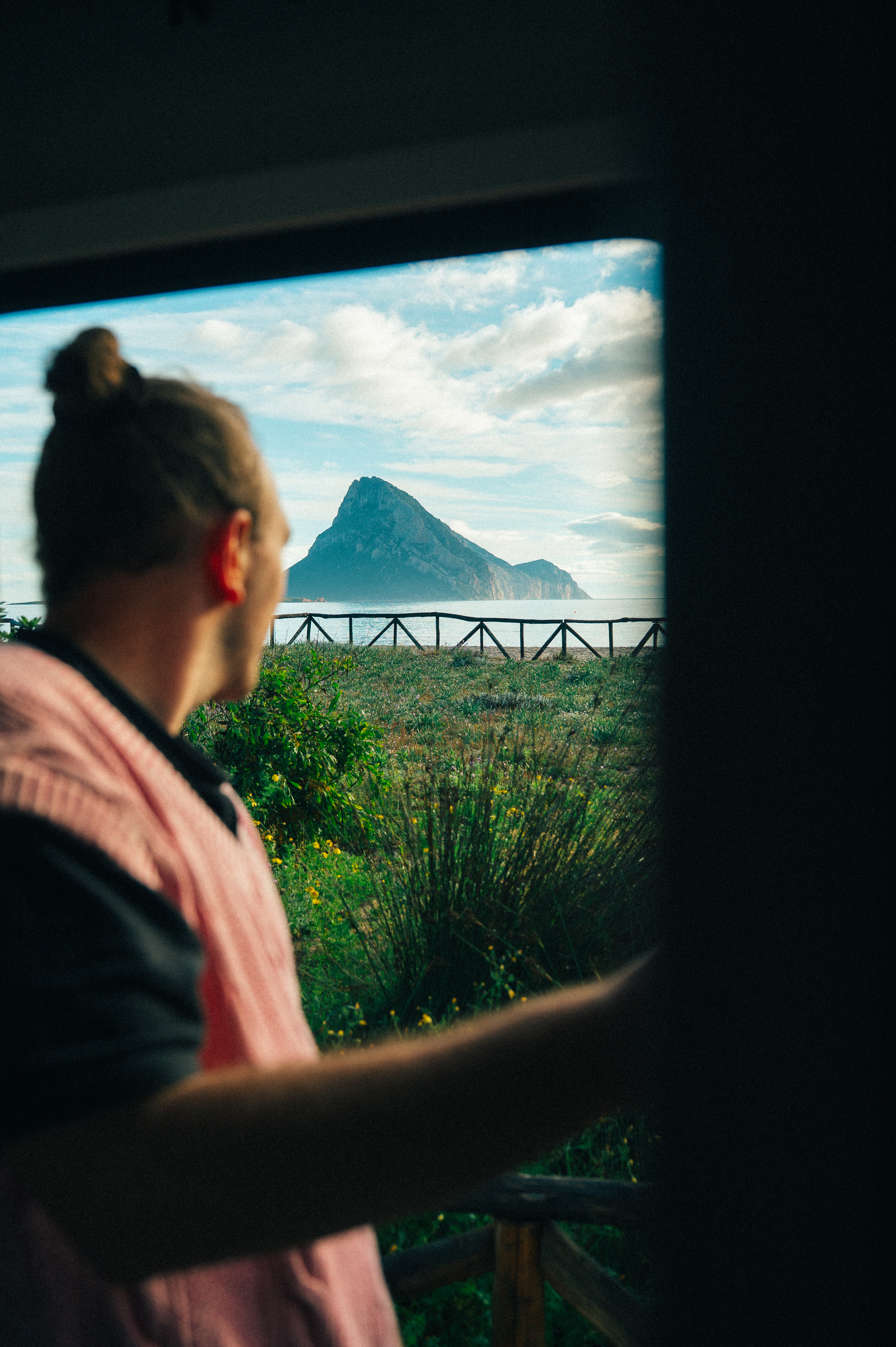 Mann blickt vom Camper auf das Meer in Sardinien