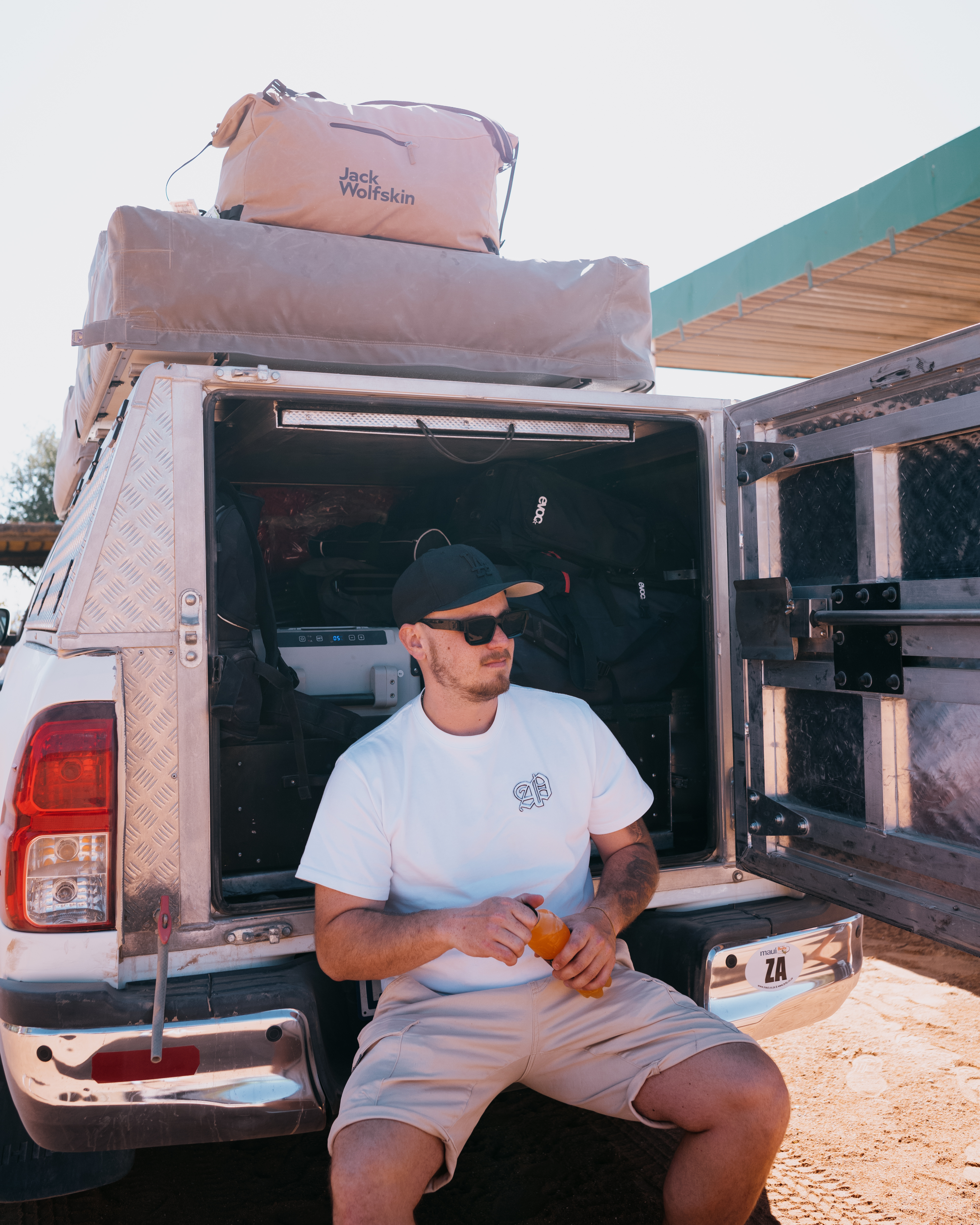 Mann sitzt vor einem Allrad-Camper in Namibia
