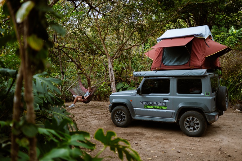 Mann sitzt vor einem Camper mit Dachzelt in Costa Rica