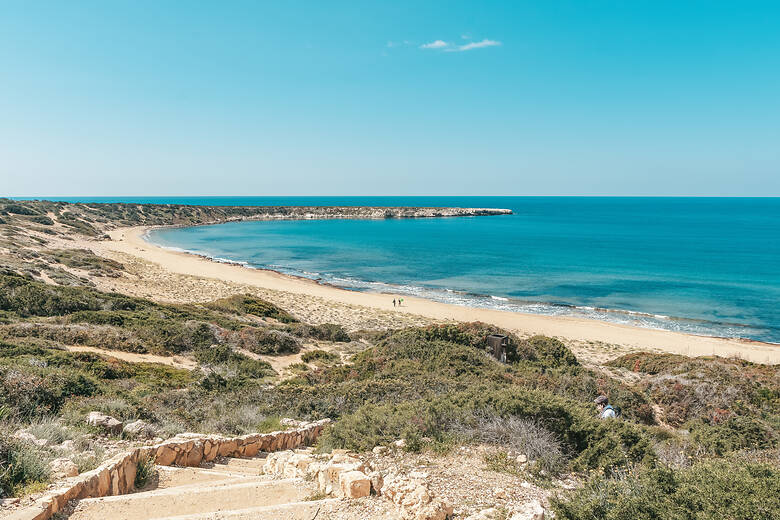 Blick über einen Sandstrand auf Zypern bis ans Meer