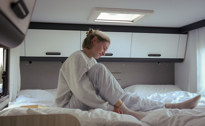 Vrouw op het bed in de camper
